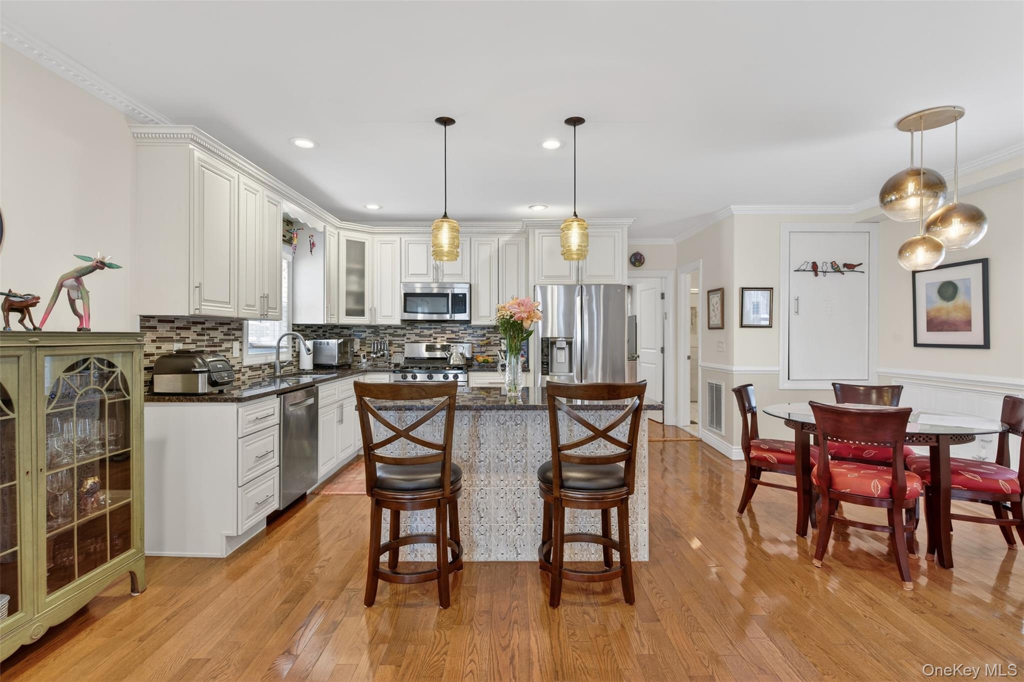 35 Kent Street Beacon, NY 12508 - Photo 17 of 42 a kitchen with stainless steel appliances kitchen island granite countertop a dining table chairs and white cabinets