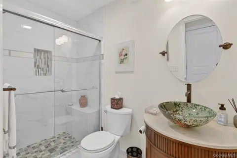 a bathroom with a sink a toilet and shower