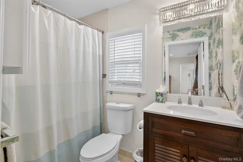 a bathroom with a sink a toilet and shower curtain