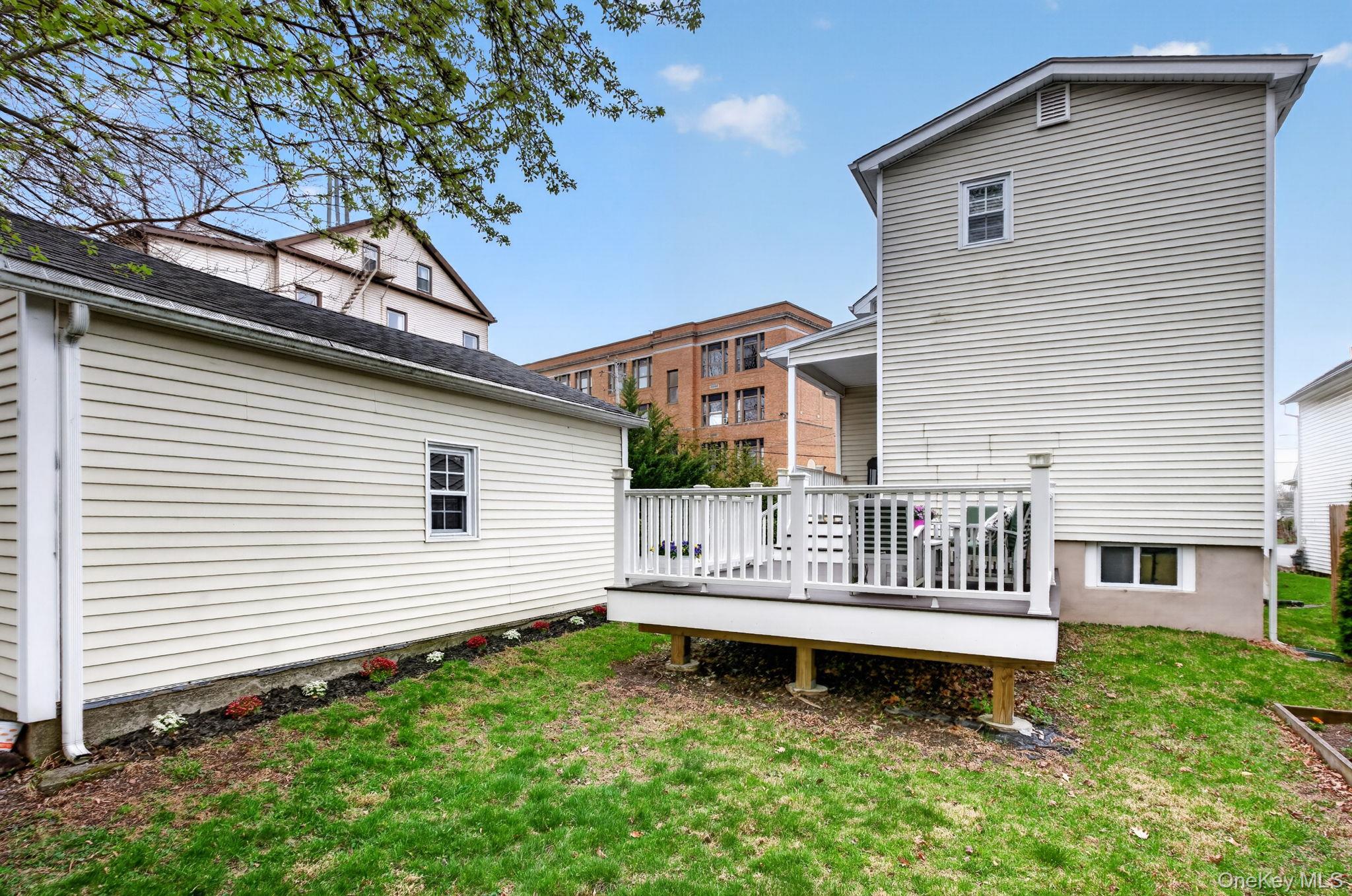 35 Kent Street Beacon, NY 12508 - Photo 38 of 42 a white house that has a small yard and large trees