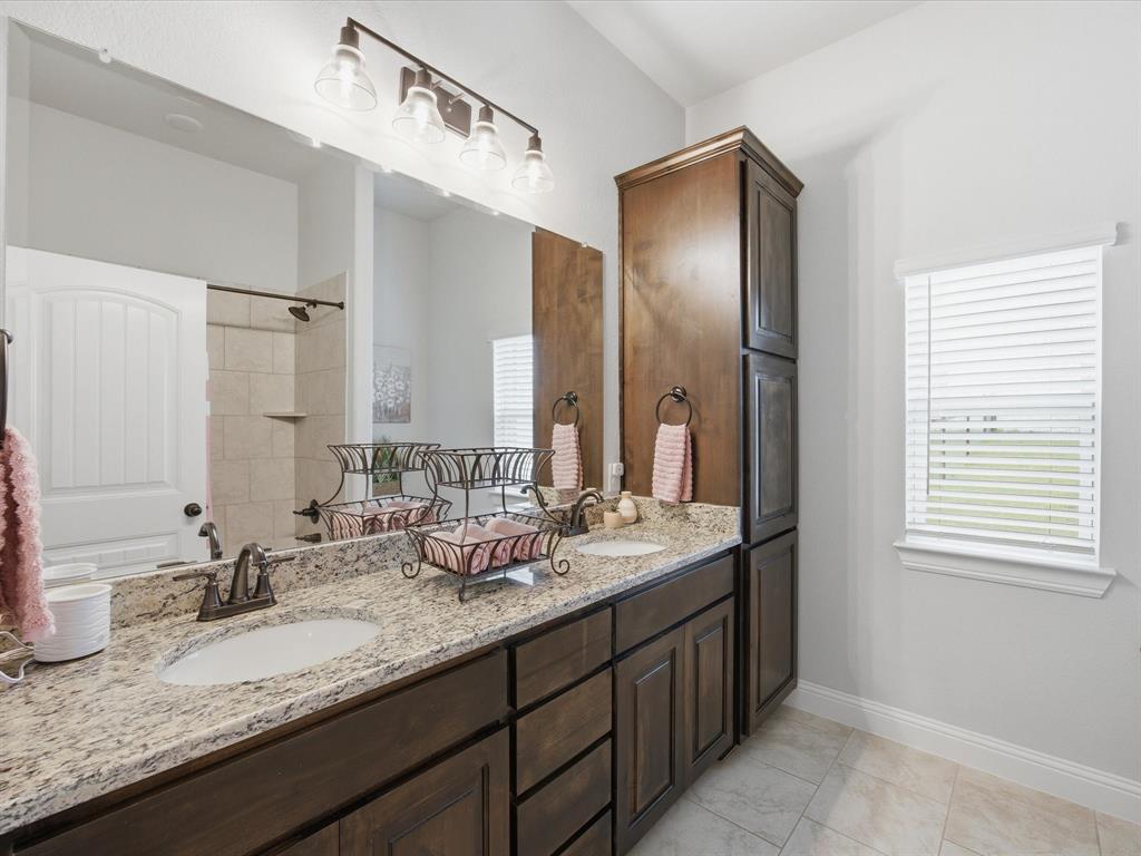 150 Quail Ridge Decatur, TX 76234 - Photo 28 of 32 a bathroom with a granite countertop double vanity sink and a mirror