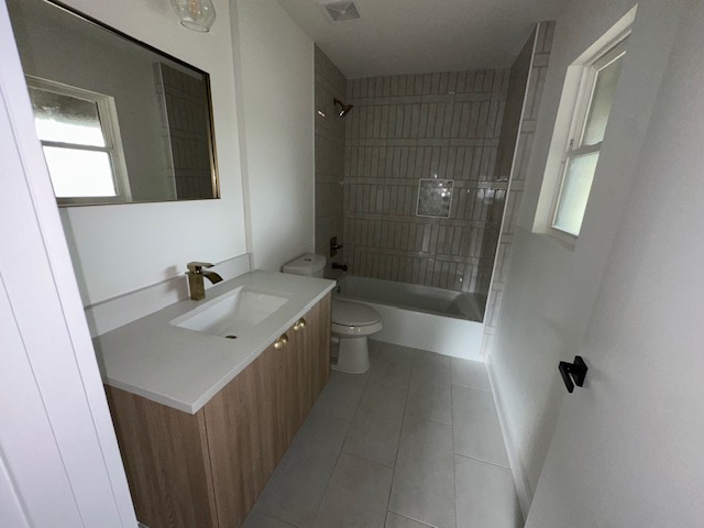 2101 Vanderbilt Lane Austin, TX 78723 - Photo 11 of 11 Bathroom featuring vanity, light tile patterned floors, and shower / bathtub combination