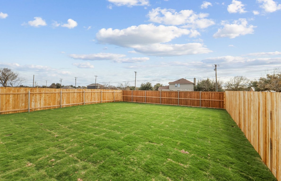 337 Sullivan Way Elgin, TX 78621 - Photo 22 of 25 a view of a green yard with a lake