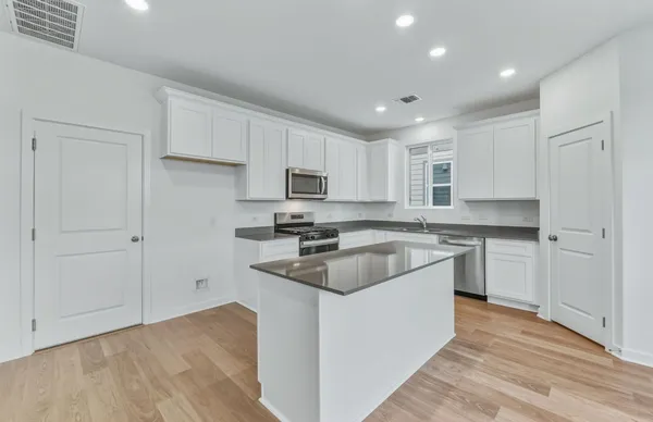 a kitchen with a white stove top oven and white cabinets