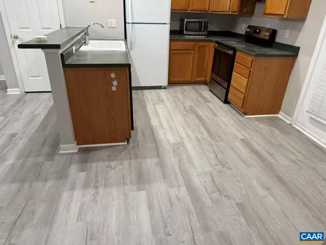 a kitchen with a sink and wooden floor