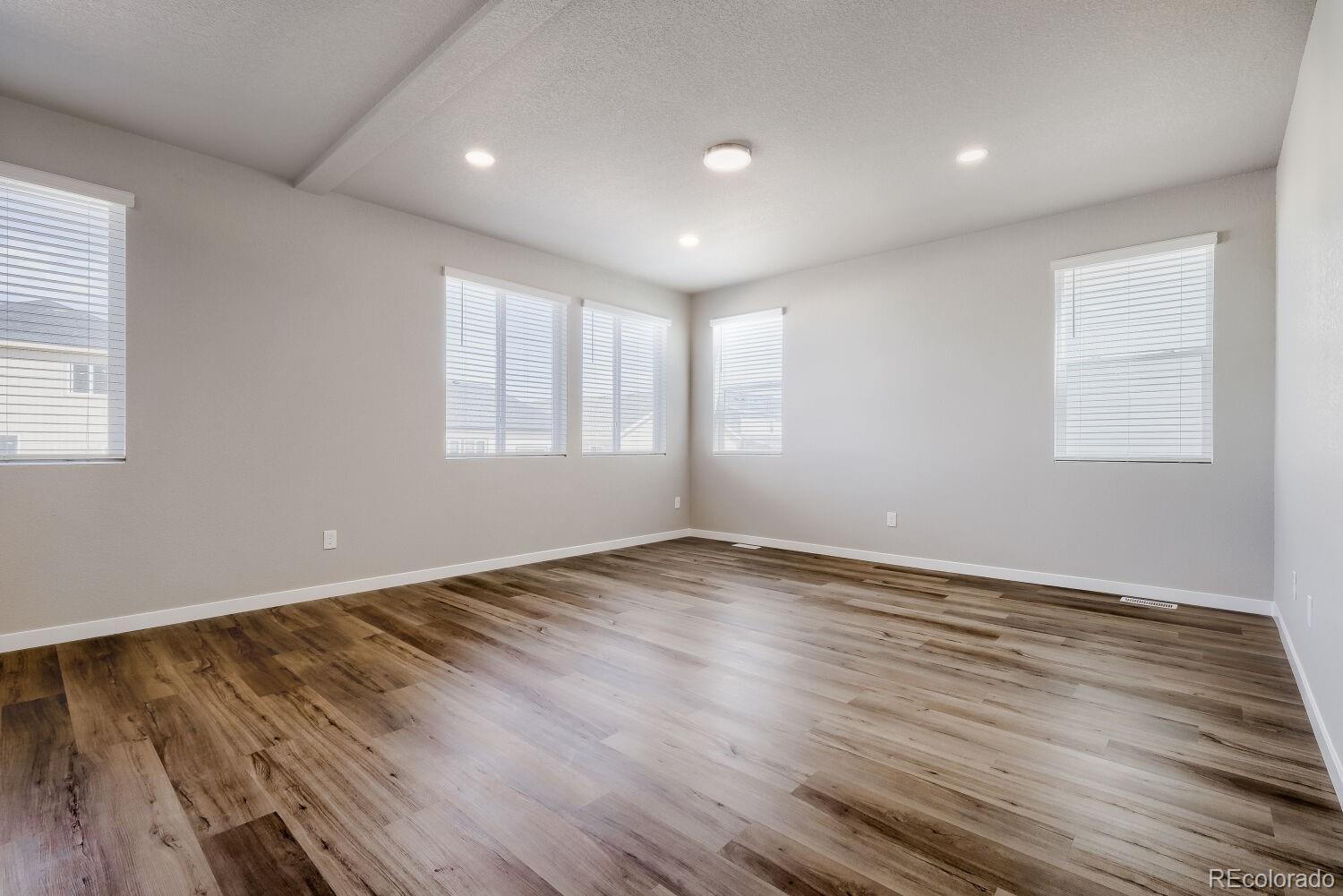 471 Atchison Way Calhan, CO 80808 - Photo 5 of 31 an empty room with wooden floor and windows