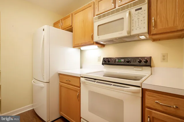a kitchen with white cabinets and white appliances