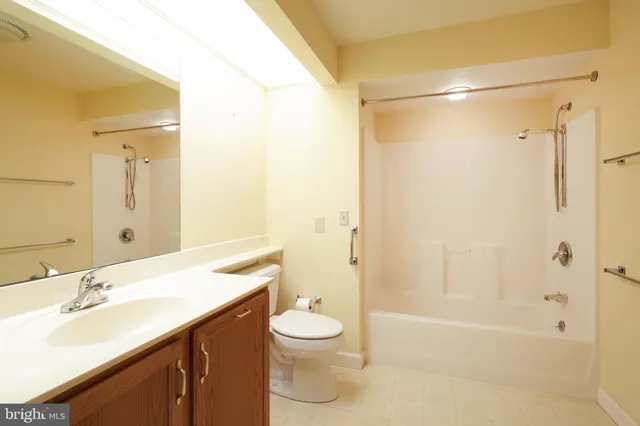 a bathroom with a granite countertop sink a toilet and shower