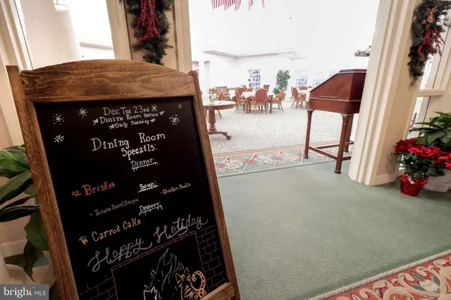 a living room with furniture kitchen view and large windows