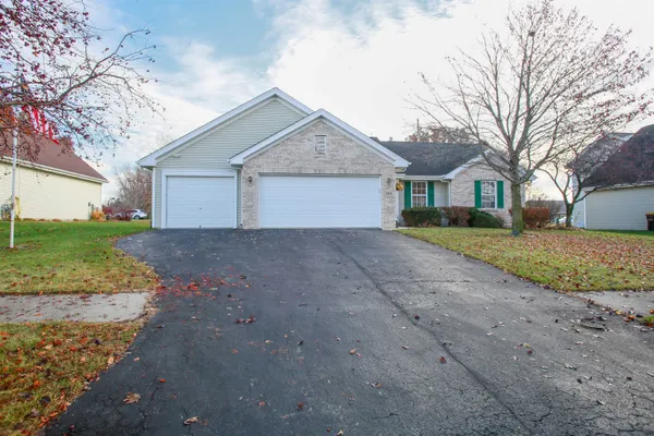 a view of a house with a yard and large tree