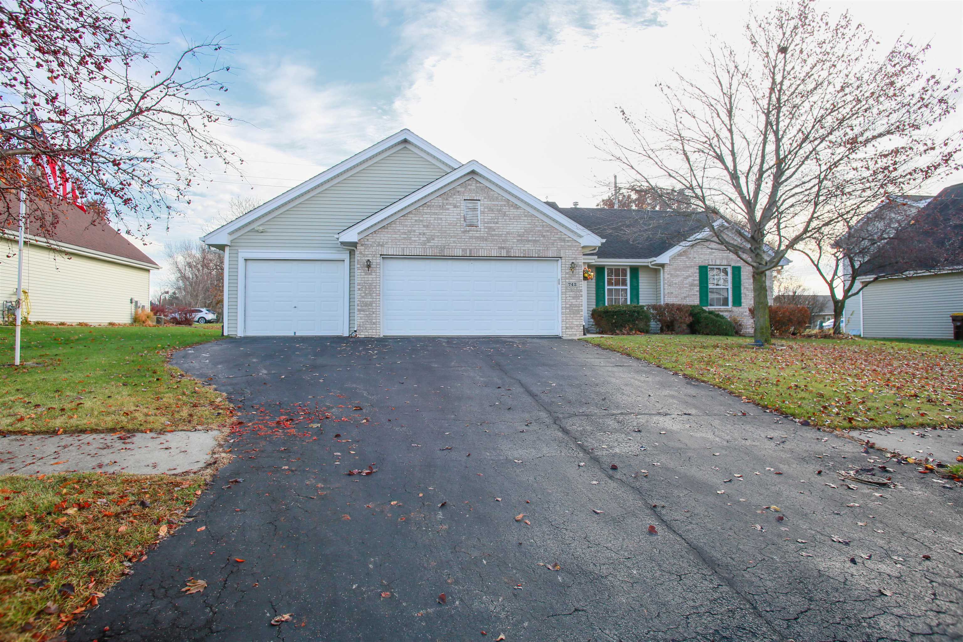 a view of a house with a yard and large tree