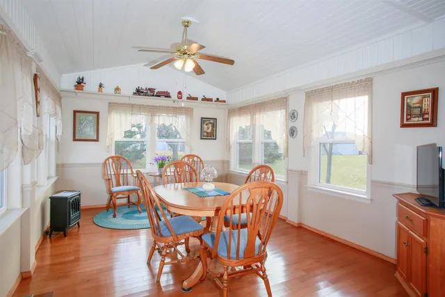 a dining room with furniture a chandelier and wooden floor