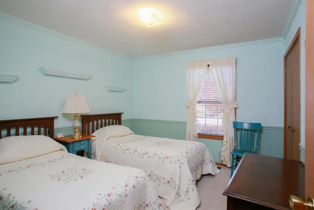 a bedroom with two beds and a desk
