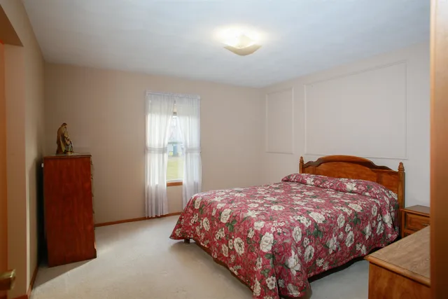 a bed sitting in a bedroom next to a window