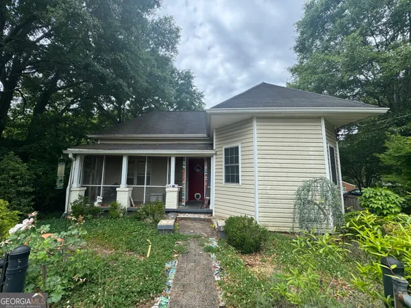 a front view of a house with a yard and potted plants