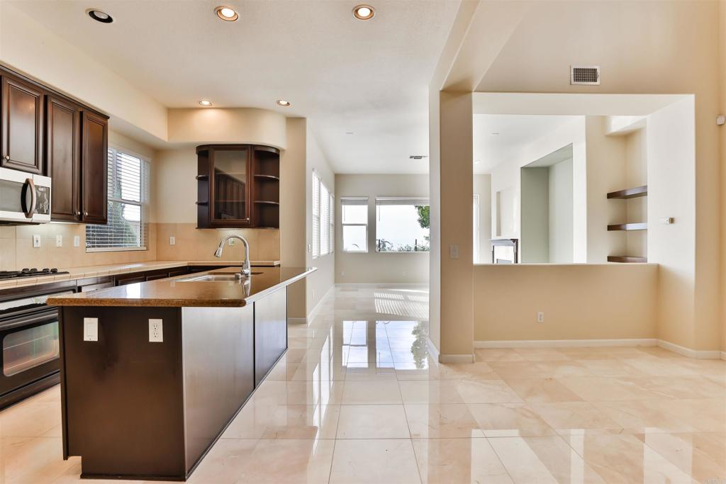 11477 Miro Circle San Diego, CA 92131 - Photo 8 of 36 a large kitchen with stainless steel appliances kitchen island granite countertop a sink and cabinets
