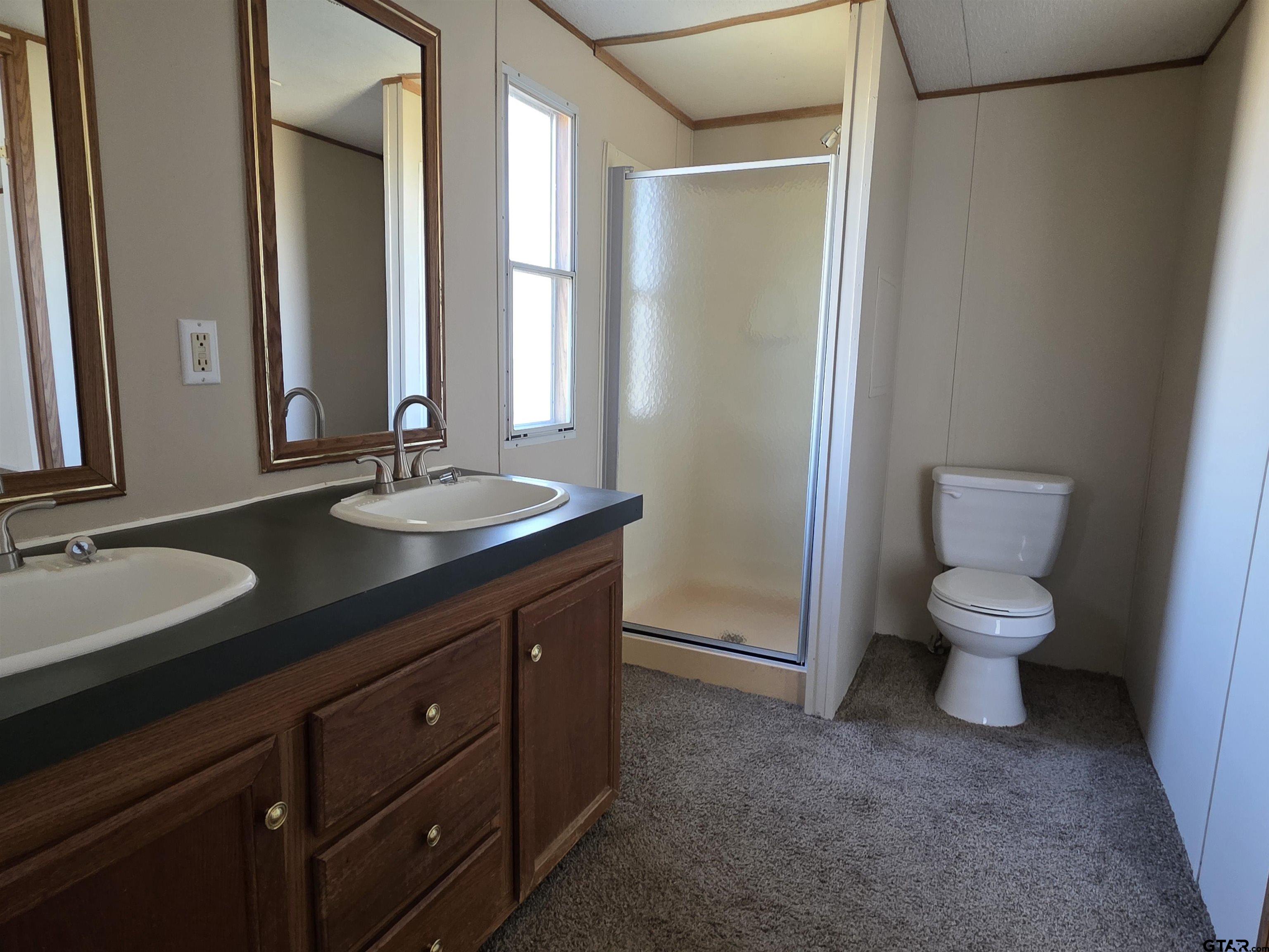 281 Sioux Quitman, TX 75783 - Photo 18 of 33 a spacious bathroom with a double vanity sink toilet and a mirror