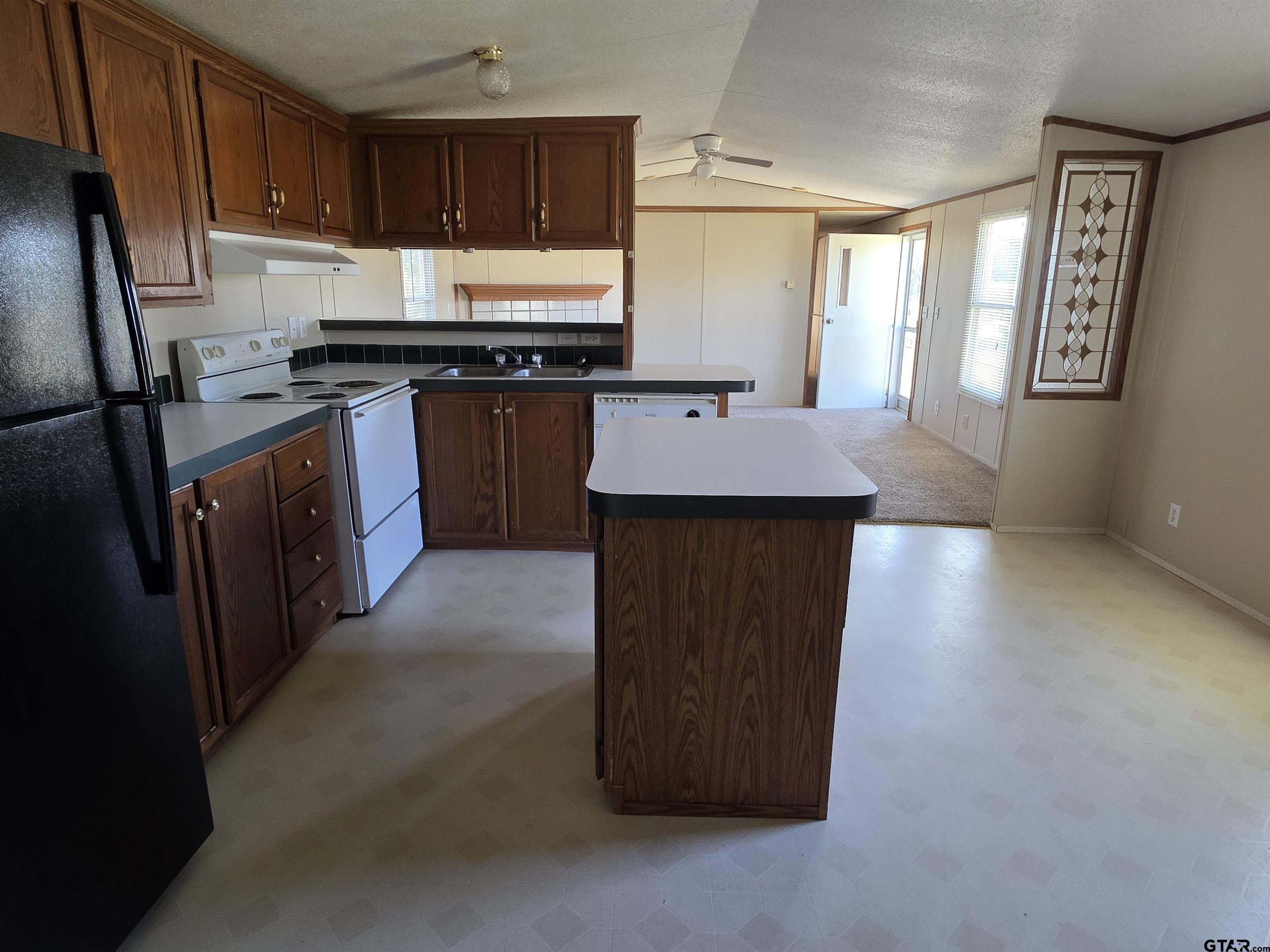 281 Sioux Quitman, TX 75783 - Photo 8 of 33 a kitchen with kitchen island granite countertop a stove top oven a sink dishwasher and a refrigerator