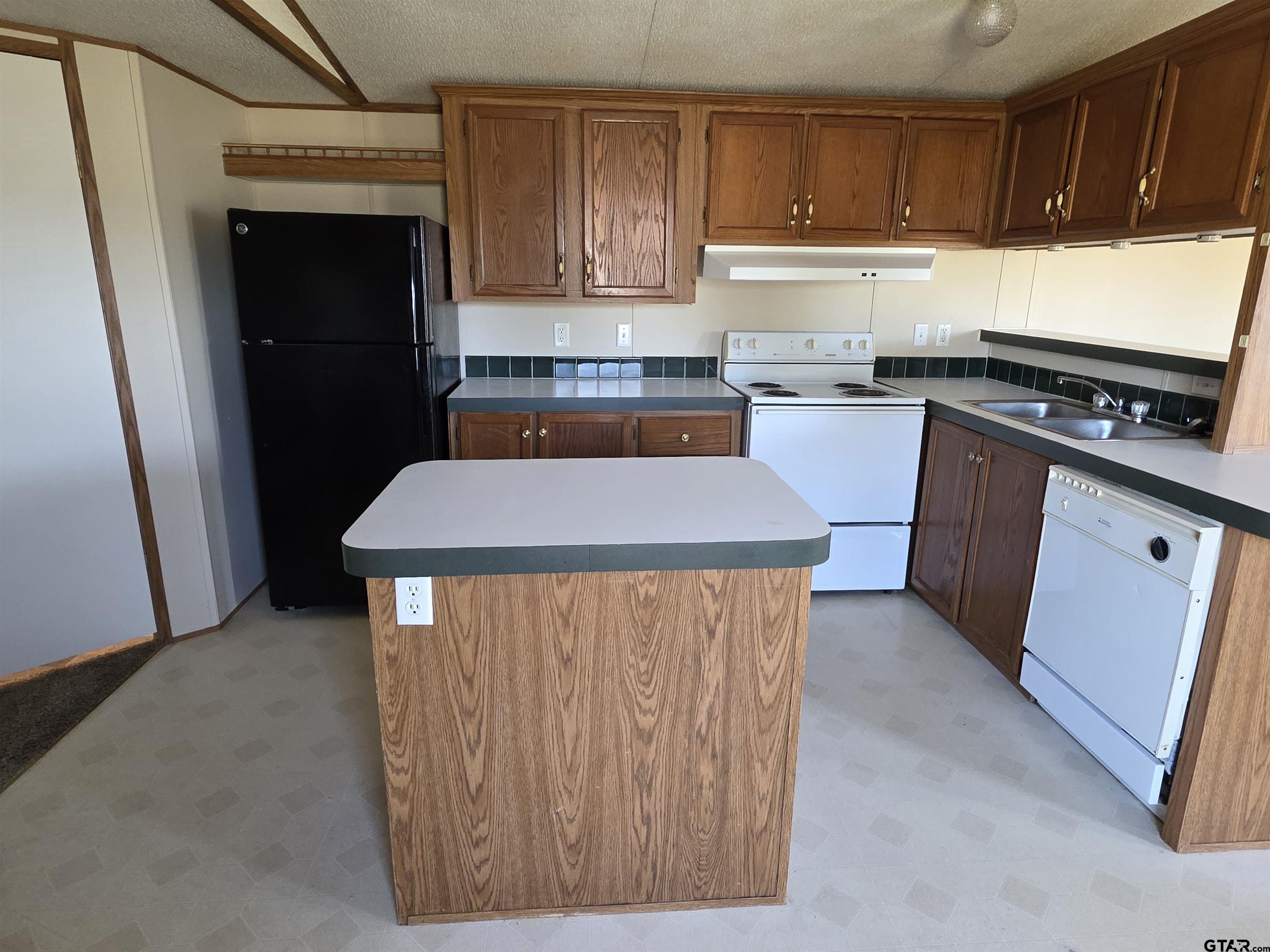 281 Sioux Quitman, TX 75783 - Photo 9 of 33 a kitchen with stainless steel appliances kitchen island granite countertop wooden cabinets a sink and a counter space