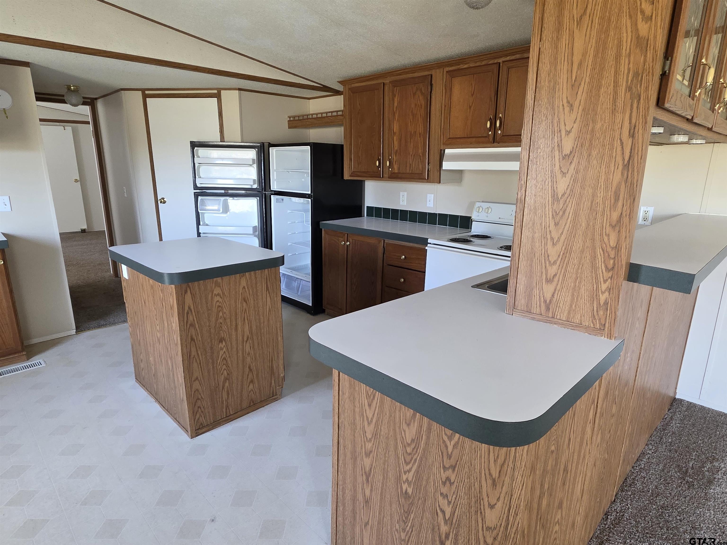 281 Sioux Quitman, TX 75783 - Photo 10 of 33 a kitchen with stainless steel appliances a stove a refrigerator a sink dishwasher and wooden cabinets