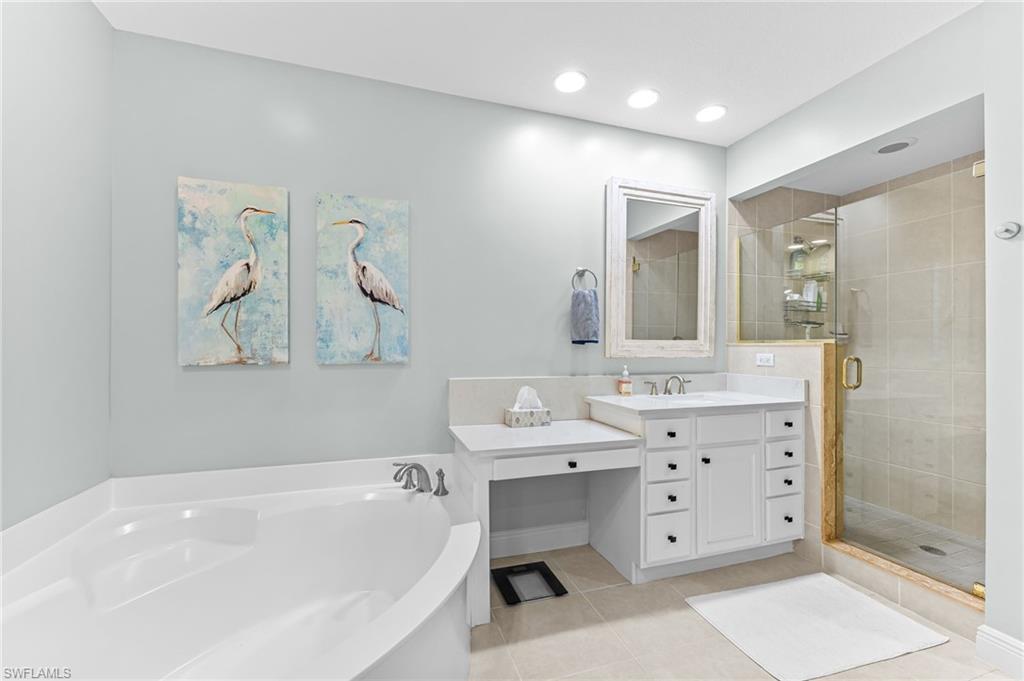 6418 Legacy Circle, Unit 802 Naples, FL 34113 - Photo 16 of 47 a bathroom with a bathtub sink and mirror