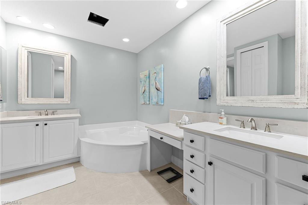 6418 Legacy Circle, Unit 802 Naples, FL 34113 - Photo 17 of 47 a bathroom with a double vanity sink mirror and bathtub