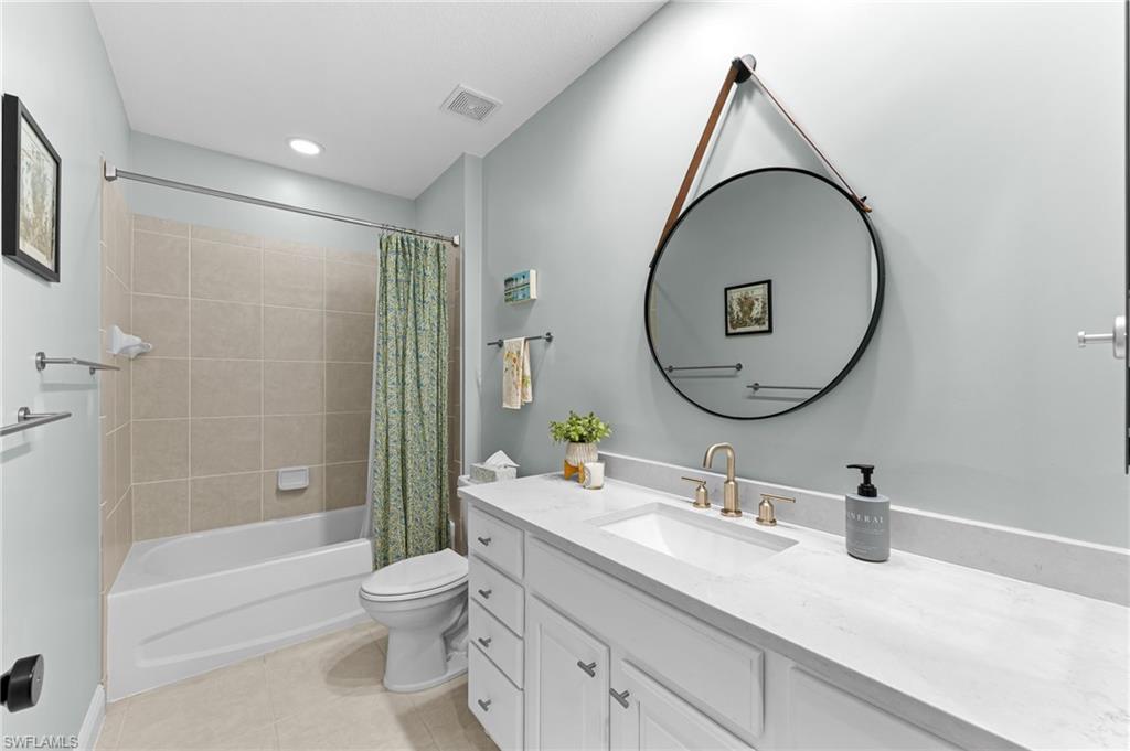 6418 Legacy Circle, Unit 802 Naples, FL 34113 - Photo 19 of 47 a bathroom with a granite countertop toilet a sink and a mirror