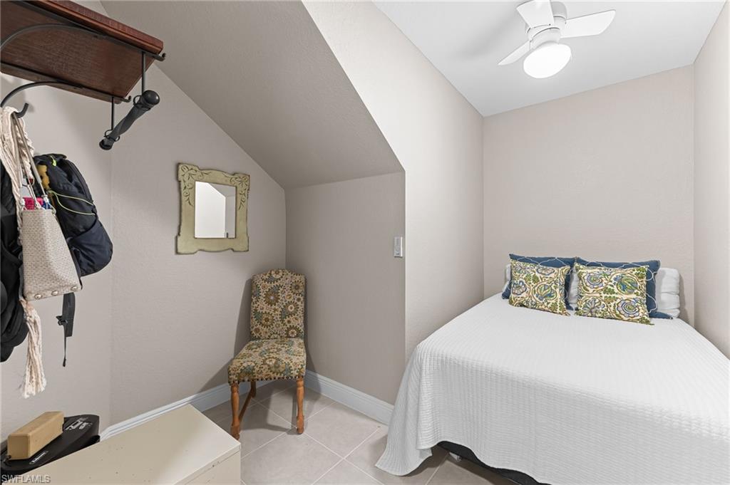 6418 Legacy Circle, Unit 802 Naples, FL 34113 - Photo 22 of 47 a bedroom with a bed and a chair