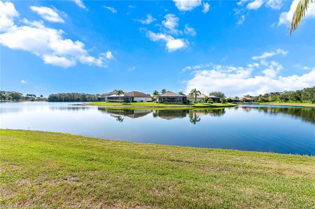 6418 Legacy Circle, Unit 802 Naples, FL 34113 - Photo 28 of 47 a view of a lake with houses in the back