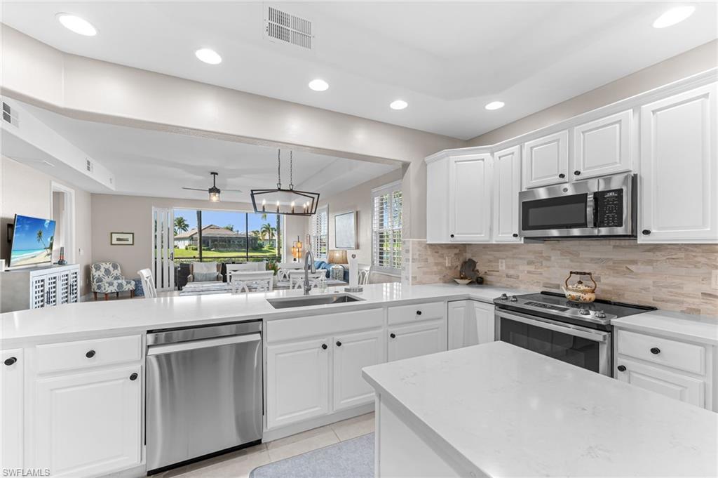 6418 Legacy Circle, Unit 802 Naples, FL 34113 - Photo 47 of 47 a kitchen with appliances a sink and cabinets