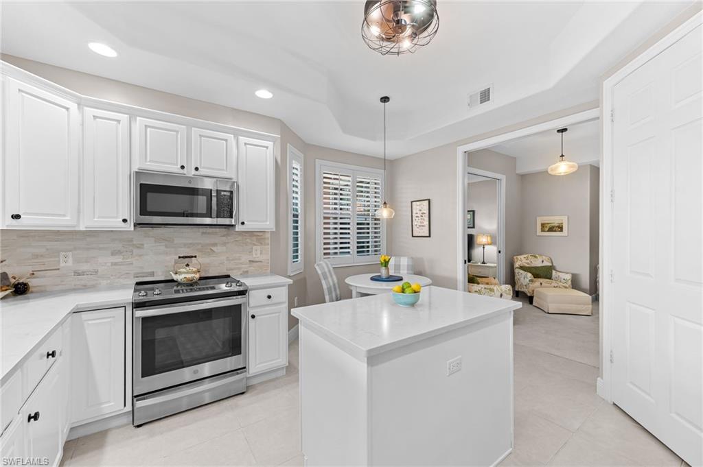 6418 Legacy Circle, Unit 802 Naples, FL 34113 - Photo 8 of 47 a kitchen that has a sink and a stove in it