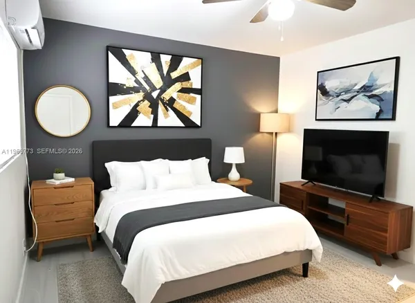 a bedroom with a bed and a flat screen tv