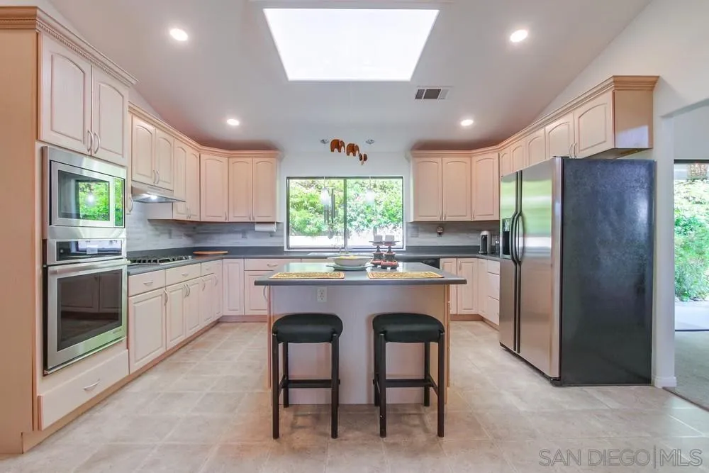 924 Ridge Heights Drive Fallbrook, CA 92028 - Photo 27 of 75 a kitchen with granite countertop stainless steel appliances a refrigerator a sink a stove a microwave a center island and cabinets