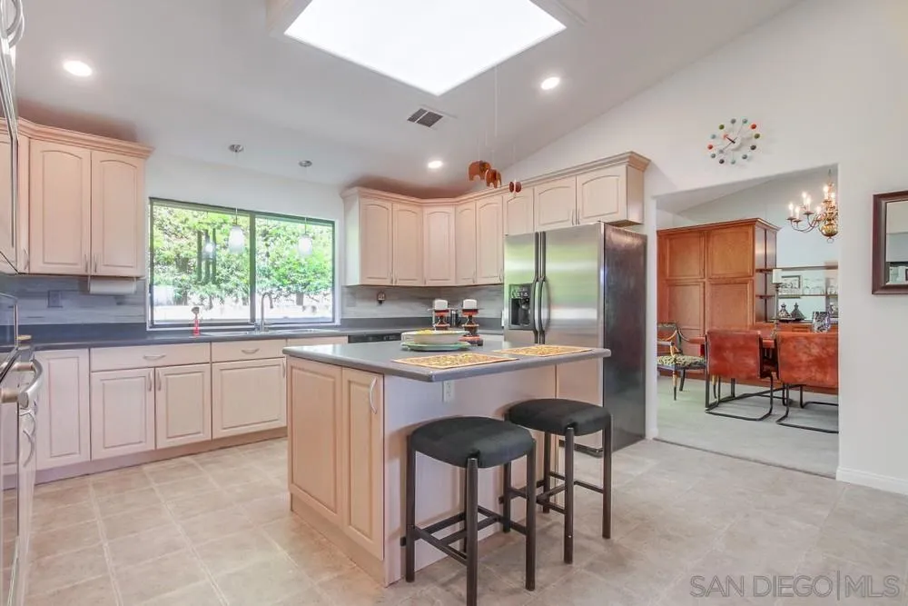 924 Ridge Heights Drive Fallbrook, CA 92028 - Photo 28 of 75 a kitchen with kitchen island granite countertop wooden cabinets and refrigerator