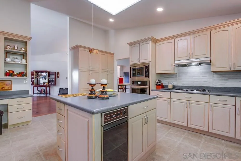 924 Ridge Heights Drive Fallbrook, CA 92028 - Photo 32 of 75 a kitchen with kitchen island granite countertop a sink a stove and cabinets