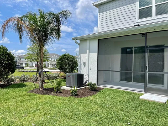 a backyard of a house with table and chairs potted plants