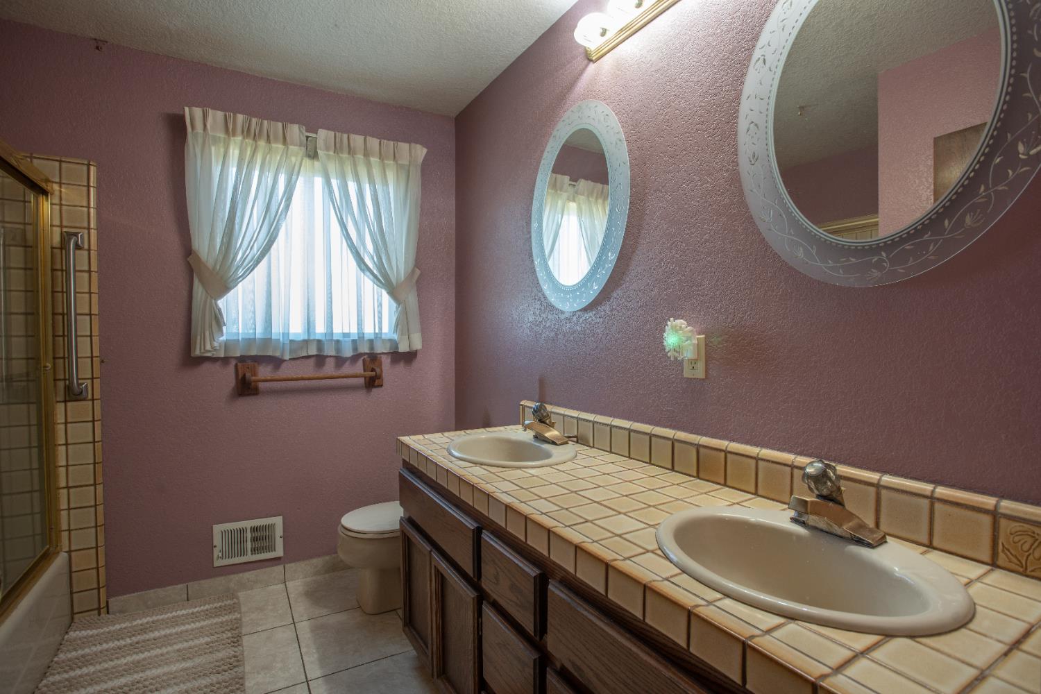 6323 Excelsior Road Sacramento, CA 95830 - Photo 31 of 75 a bathroom with a granite countertop toilet a sink and a mirror