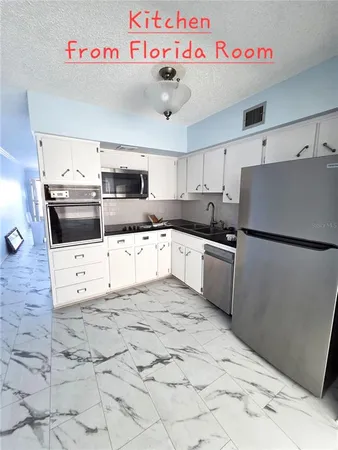 a kitchen with granite countertop a sink and cabinets