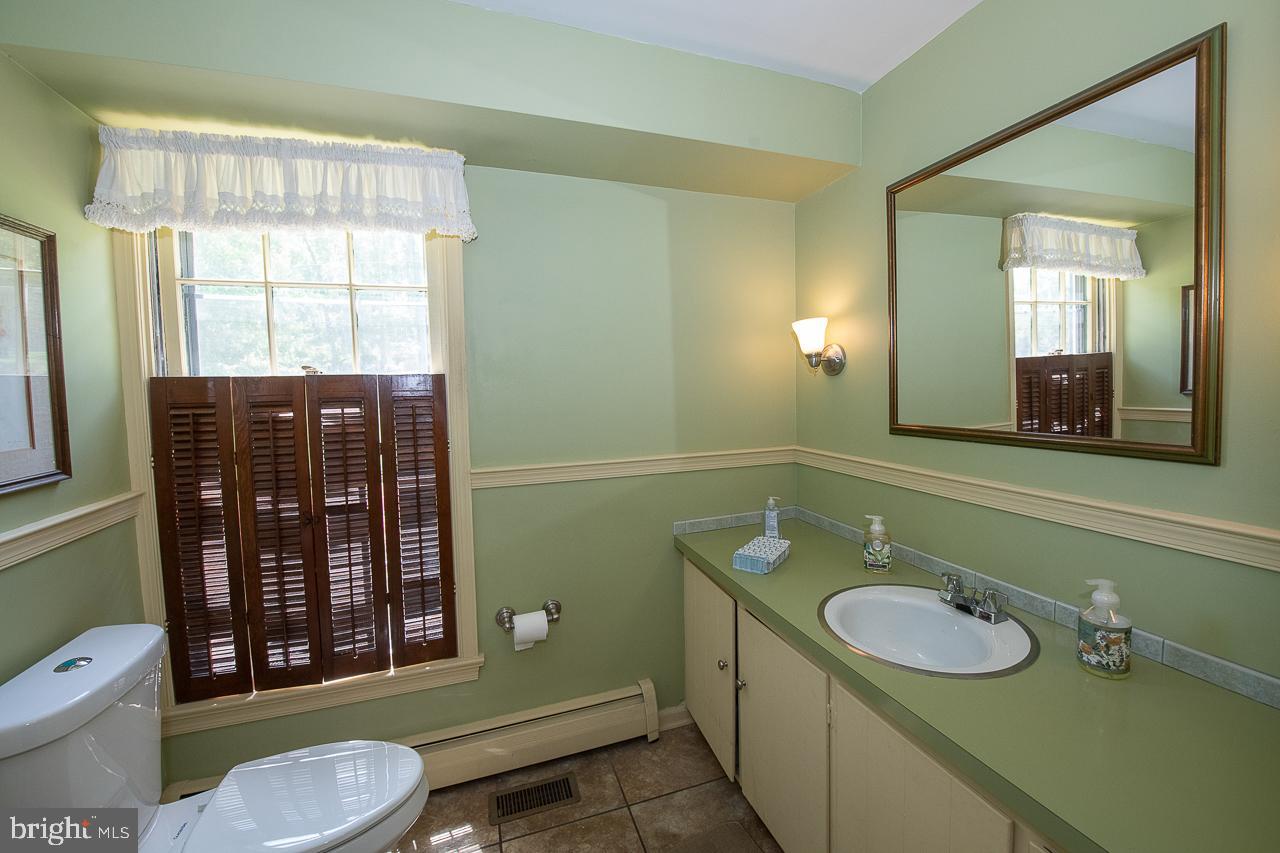 247 Church Road Devon, PA 19333 - Photo 18 of 35 a bathroom with a granite countertop toilet sink and mirror