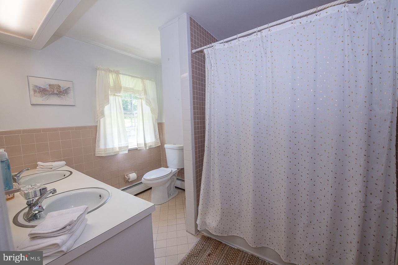247 Church Road Devon, PA 19333 - Photo 27 of 35 a bathroom with a sink a toilet and a window