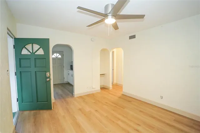 an empty room with a window and a ceiling fan