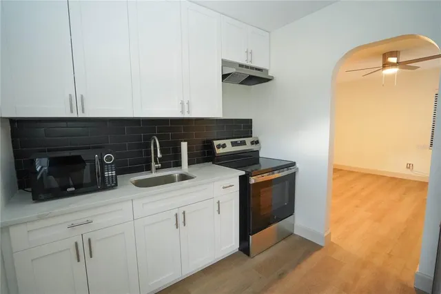 a kitchen with a sink stove and cabinets