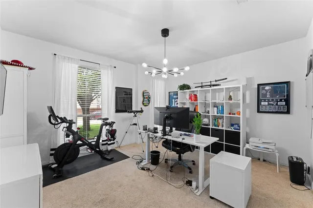 a view of a dining room with furniture a kitchen and chandelier