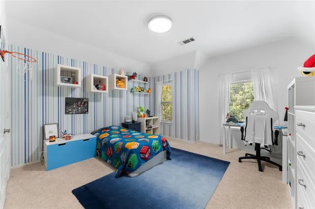 a bedroom with a bed and a flat tv screen on dresser