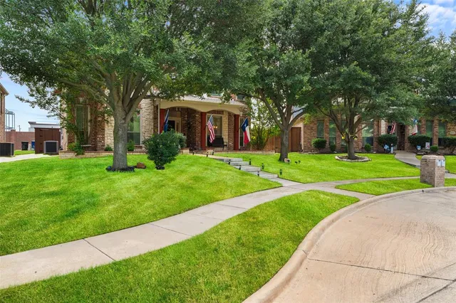 a view of a house with a big yard and large trees