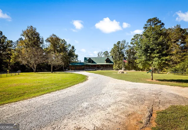 a front view of house with yard and trees in the background