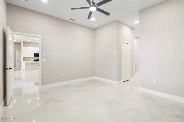 an empty room with fan and windows