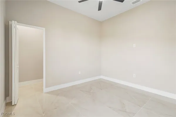 an empty room with a window and a fan
