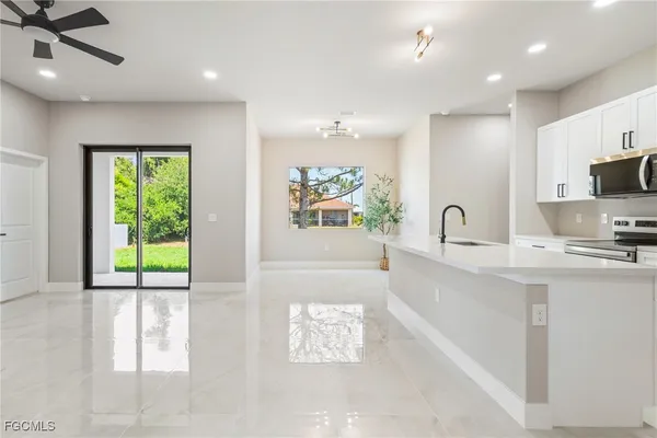 a large white kitchen with a large window
