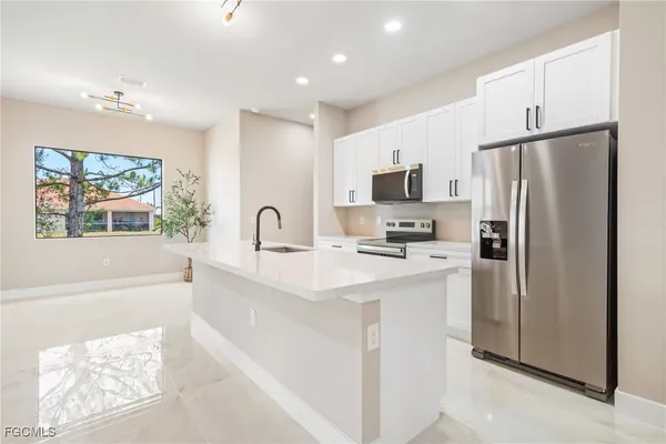 a kitchen with stainless steel appliances a refrigerator sink and microwave
